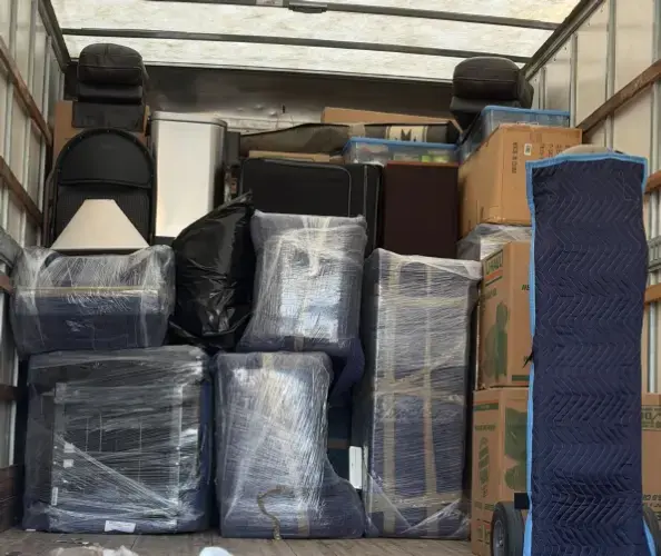 Fully loaded moving truck with wrapped furniture, boxes, and household items