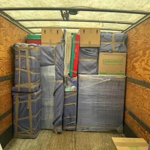 Fully packed moving truck with wrapped furniture and labeled boxes